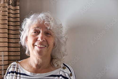 Portrait of an elderly smiling gray-haired curly lady with long hair, copy space.