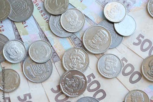 Ukraine money coins lying on mixed hryvnia banknotes. Finance background concept. photo