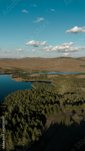 Nature of western Serbia in early autumn on a sunny warm day. Aerial sunset view from a drone of Lake Ribnichko in Zlatibor national park, next to the cable car leading to Mount Tornik.