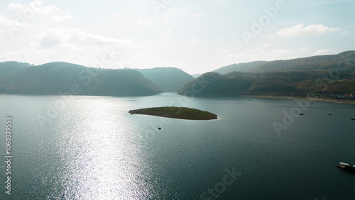 Beautiful artificial mountain lake Zlatar in Serbia ideal for fishing, swimming and recreation - Zlatarsko jezero. Aerial view, drone shot. A small island and fishing boats. photo