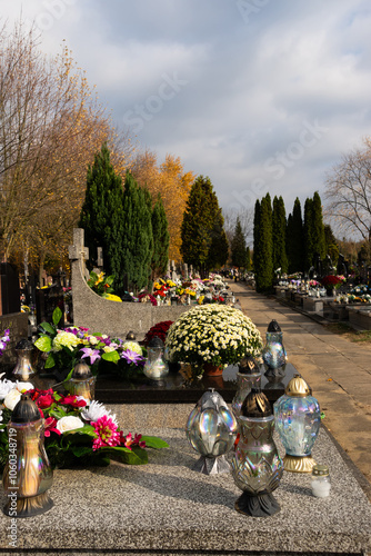 Obraz na płótnie Graves with candles during the All Souls' Day celebration on November 1st. Photo taken during the day in natural light w salonie