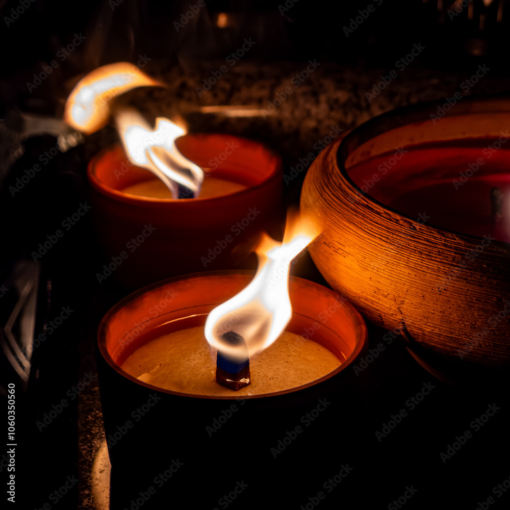 Flames on clay cemetery candles standing on tombstones. The shot was taken in the evening of All Saints' Day, November 1.
