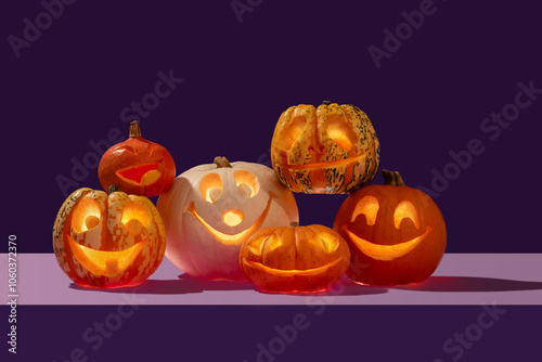 Halloween variety of happy face pumpkins gang on a pile like a singing choir in contrast orange and purple