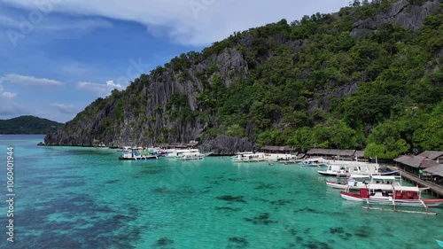 Stunning Aerial View of a Small Lagoon with Boats in Turquoise Waters Surrounded by Lush Green Mountains in the Philippines – High-Resolution 4K