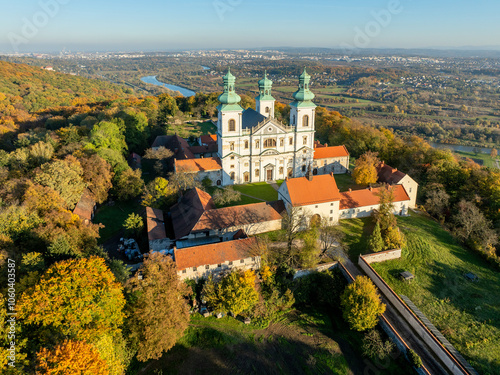 Obraz na płótnie Active Camaldolese monastery and baroque church in a wood on the hill in Bielany, Krakow, Poland., Aerial view in sunset light in fall with Vistula River and far view of Cracow city in the background w salonie