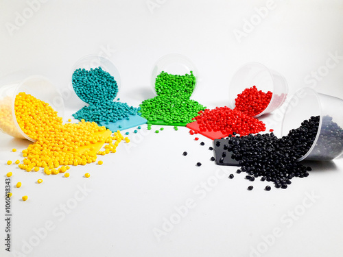 Various colors of masterbatch granules are poured onto the color chip, a polymer that carries color pigments in the plastics industry. photo