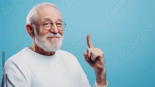 A thoughtful elderly man sharing his insightful idea while set against a calming blue background, embodying wisdom and experience