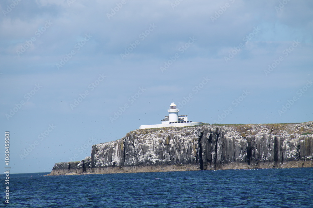 A White Lighthouse on the Edge of a Rocky Ocean Island. A White Lighthouse on the Edge of a Rocky Ocean Island.