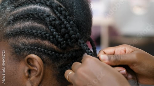Hairdresser making crochet braids to a client in an afro hair salon