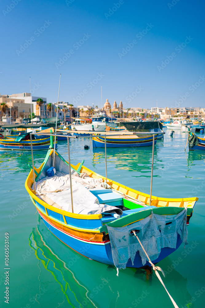 Obraz premium Traditional colorful fishing boats Luzzu in the Harbor of Mediterranean fishing village Marsaxlokk at sunny day, Malta.