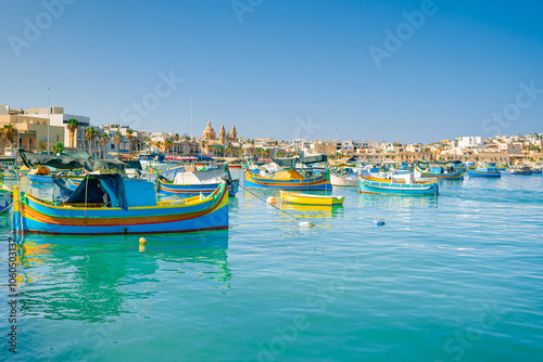 Traditional colorful fishing boats Luzzu in the Harbor of Mediterranean fishing village Marsaxlokk at sunny day, Malta.