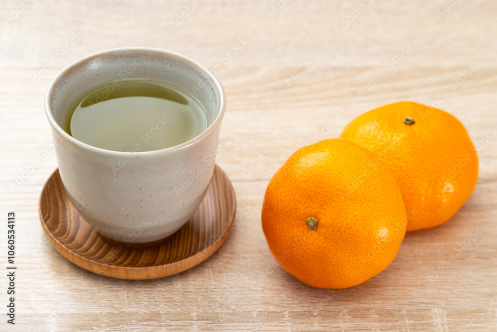 テーブルに置かれたミカンと緑茶 テーブルに置かれたミカンと緑茶
