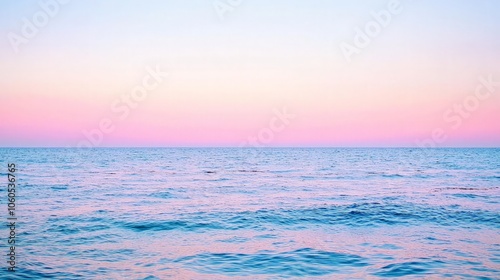 A serene seascape with a soft pink and blue sky at sunset, the ocean is calm and tranquil.