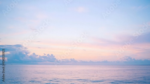 Blurred background of a tranquil seascape with soft pink and blue hues during sunrise or sunset.