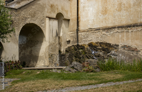 Arched vault. Arched pillar of the staircase. Stairs to enter the castle. Rock. The facade of the castle transitioning from the rock to the building. Nature, grass, rock, castle. photo