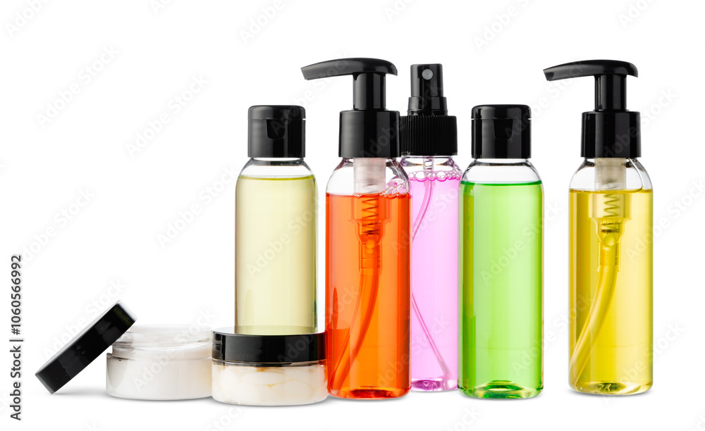 Variety of colorful personal care bottles and grooming accessories arranged on a white surface Variety of colorful personal care bottles and grooming accessories arranged on a white surface