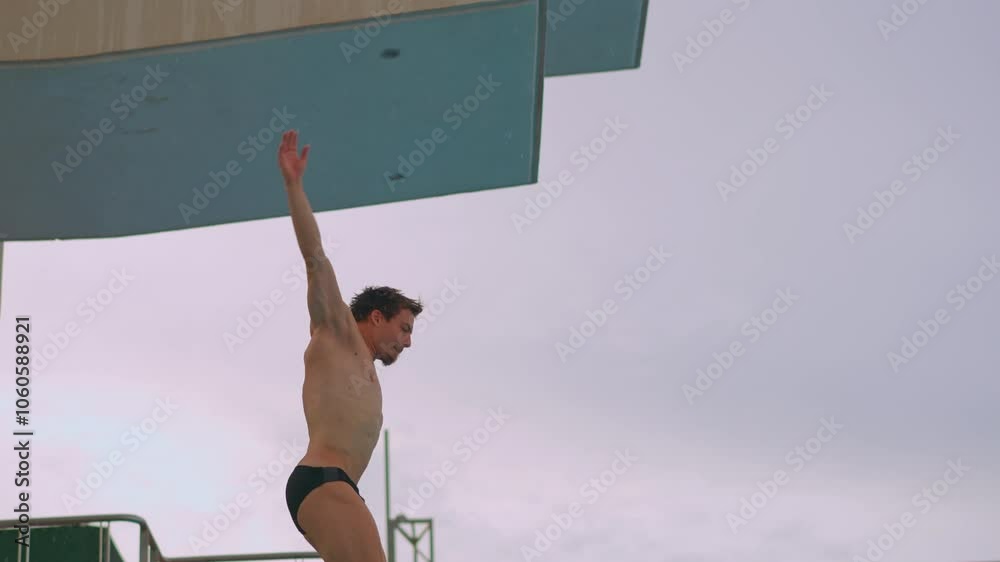 A professional athlete perfects his spring dive during training. The video showcases his dedication, technique, and athletic prowess as he practices each dive with precision and focus. Slowmotion