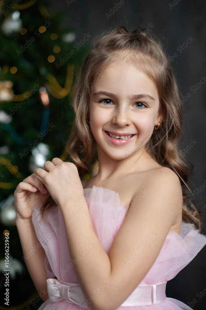 A young girl in a pink dress stands in front of a beautifully decorated Christmas tree. The photo is captured in low-key lighting, which creates a dramatic, moody atmosphere. magic Christmas. A young girl in a pink dress stands in front of a beautifully decorated Christmas tree. The photo is captured in low-key lighting, which creates a dramatic, moody atmosphere. magic Christmas.