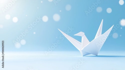 A delicate white origami crane floats gently on a serene blue background, creating a peaceful, artistic atmosphere. photo