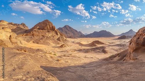 A panoramic view of a vast desert landscape with mountains and a clear blue sky.