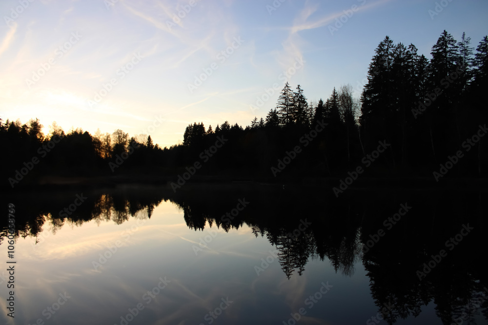 Beautiful sunset reflection with forest in a lake, Waldsee Lindenberg im Allgäu Beautiful sunset reflection with forest in a lake, Waldsee Lindenberg im Allgäu