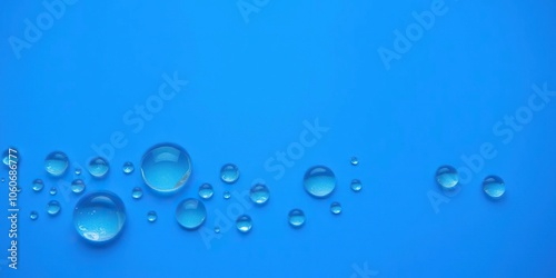 Water drops in various sizes and shapes sit delicately on a vibrant blue background, creating a serene and soothing aesthetic, close-up, liquid