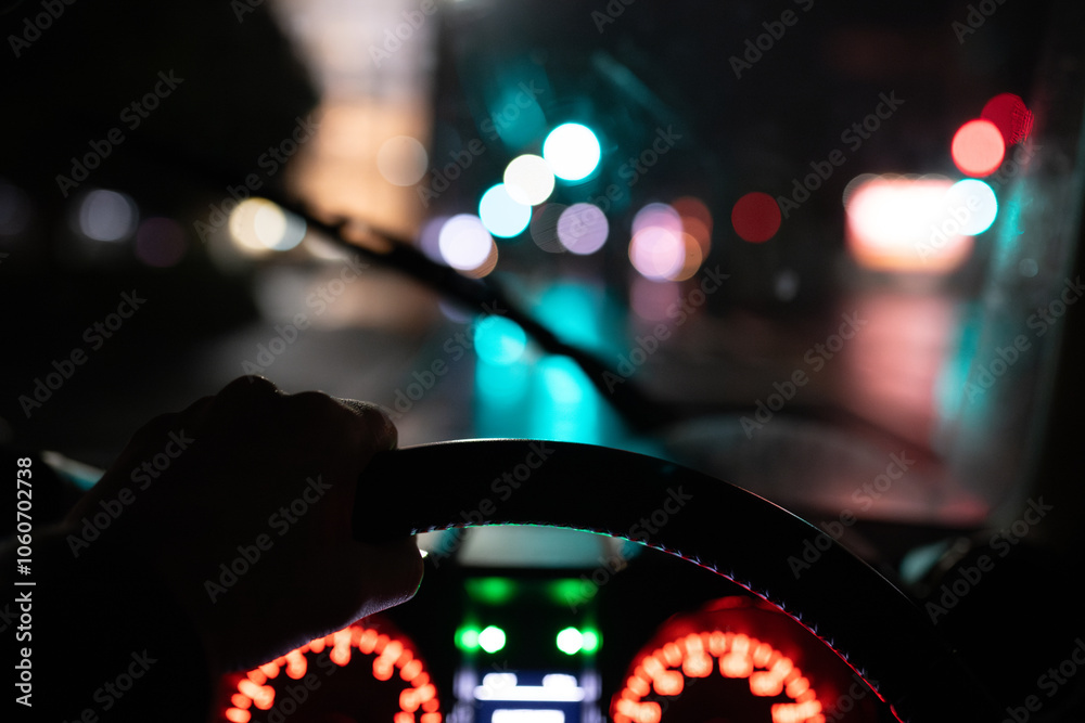 雨の夜に自動車を運転する男性の手元