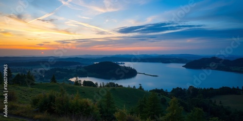 A stunning panoramic view of a colorful sunset over a peaceful lake surrounded by rolling hills and lush green trees, reflection, picturesque