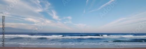 A serene ocean view with gentle waves rolling onto a sandy beach under a blue sky, beach, seascape