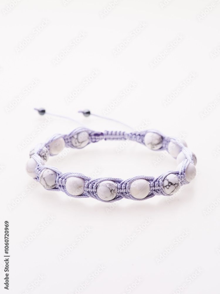 A charming double bracelet in shades of pink, made from natural stone and set against a gray background. The heart charm with cubic zirconia stands out in this close-up top view A charming double bracelet in shades of pink, made from natural stone and set against a gray background. The heart charm with cubic zirconia stands out in this close-up top view