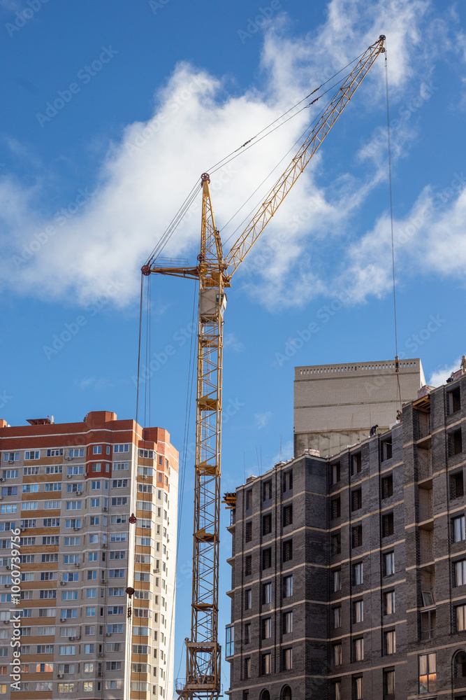 A crane is lifting a large object in front of a building A crane is lifting a large object in front of a building