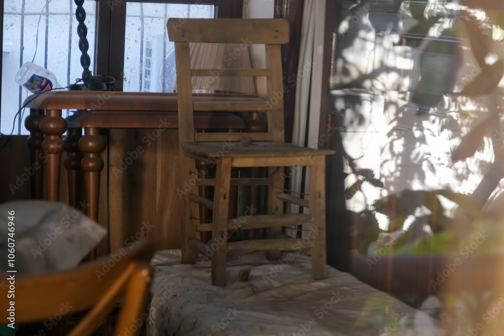 A wooden chair stands in the middle of a room, patiently waiting for a craftsman to repair it. A wooden chair stands in the middle of a room, patiently waiting for a craftsman to repair it.