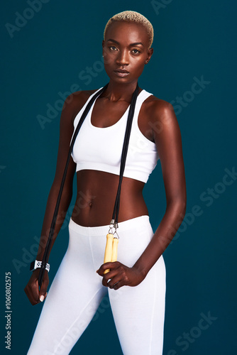 Black woman, portrait and studio for exercise, rope and ready for jumping sports on dark background. Female person, athlete and start of cardio, performance training and tool for workout practice