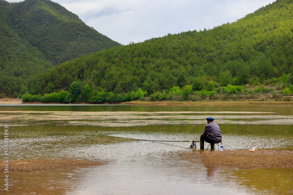 fishing man besede the lake near the mountain fishing man besede the lake near the mountain