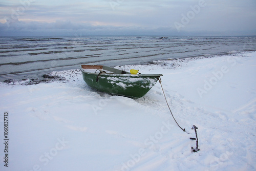 Winter landscape from the seashore,.  Fisherman boat on the seashore,  ice texture in Winter. 