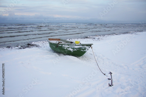 Winter landscape from the seashore,.  Fisherman boat on the seashore,  ice texture in Winter. 