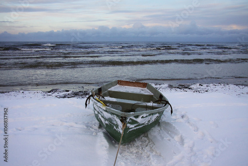 Winter landscape from the seashore,.  Fisherman boat on the seashore,  ice texture in Winter. 