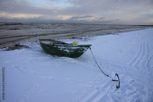 Winter landscape from the seashore,.  Fisherman boat on the seashore,  ice texture in Winter. 