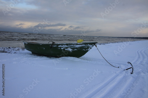 Winter landscape from the seashore,.  Fisherman boat on the seashore,  ice texture in Winter. 