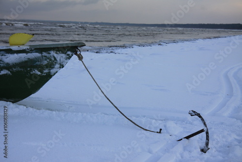 Winter landscape from the seashore, fisherman boat on the seashore, sand and ice texture in Winter. 