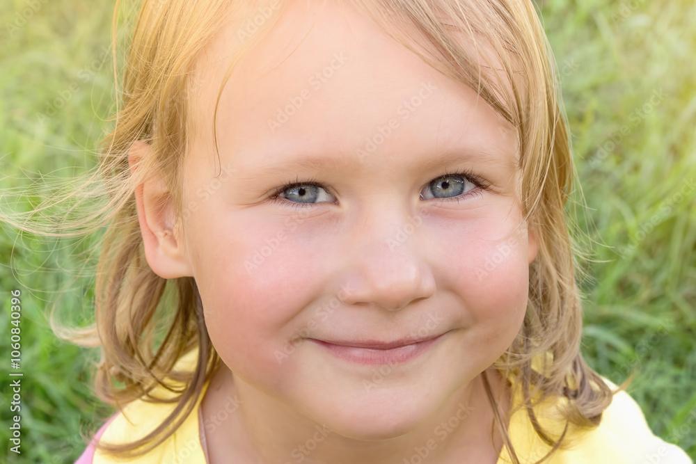 Close up of face of child girl looking at camera with happy smile on summer sunny day Close up of face of child girl looking at camera with happy smile on summer sunny day