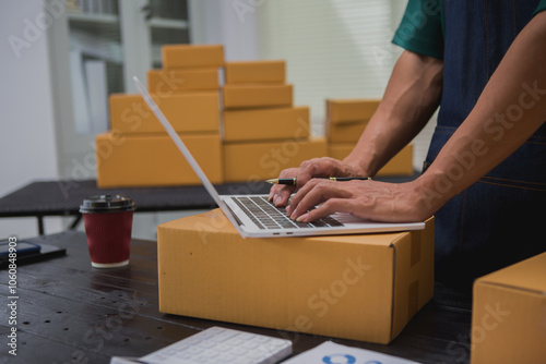 An Asian man carefully prepares a package for a customer's online order, methodically placing items in a box, sealing it securely, and attaching a shipping label for prompt delivery.