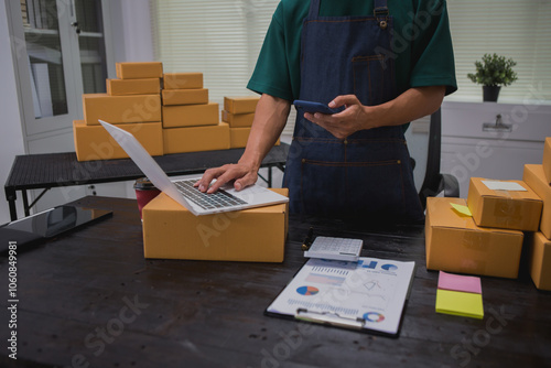 An Asian man carefully prepares a package for a customer's online order, methodically placing items in a box, sealing it securely, and attaching a shipping label for prompt delivery.