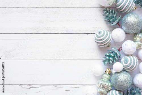 Christmas side border of white and soft green decorations. Top view on a white wood background. Copy space. photo