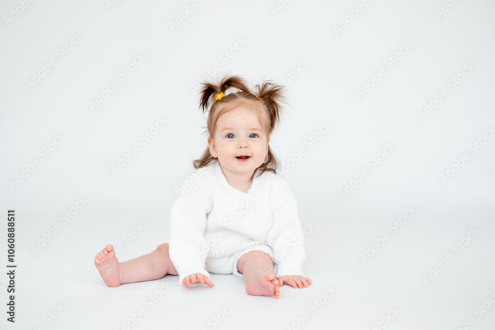 a baby girl on a white isolated background, a small child in a white knitted sweater smiling, a place for text a baby girl on a white isolated background, a small child in a white knitted sweater smiling, a place for text