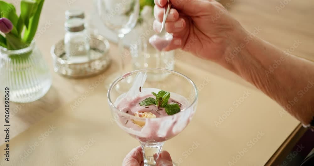 Indulging in a delicious and delightful dessert elegantly presented in a glass with fresh garnish. Hand enjoying a scrumptious dessert in a stylish glass, beautifully garnished for presentation Indulging in a delicious and delightful dessert elegantly presented in a glass with fresh garnish. Hand enjoying a scrumptious dessert in a stylish glass, beautifully garnished for presentation
