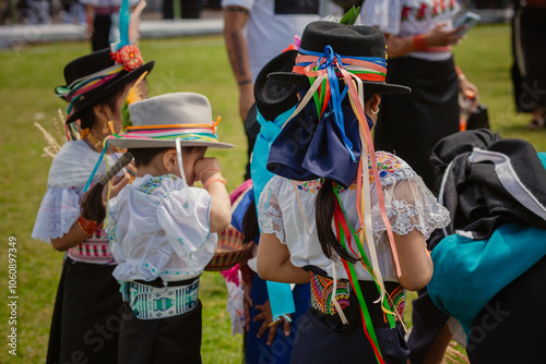 Grupo de niñas indígenas bailando con su atuendo tradicional durante la fiesta del florecimiento llamado Pawkar Raymi en la comunidad de Peguche, Otavalo, Imbabura, Ecuador, Sur América. photo