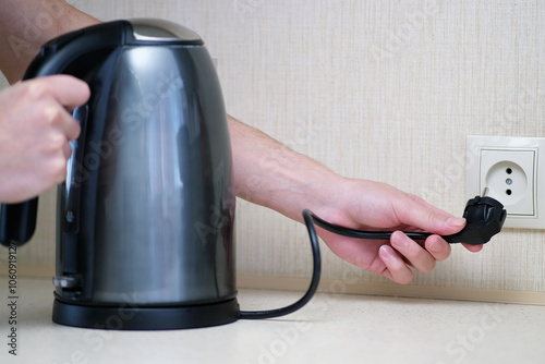 A Modern Electric Kettle Connected to a Wall Socket for Convenient and Quick Use