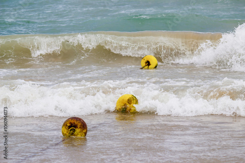 Yellow Buoys Floating in Ocean Waves photo