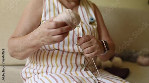 Close-up of elderly woman’s hands crocheting with thin threads photo